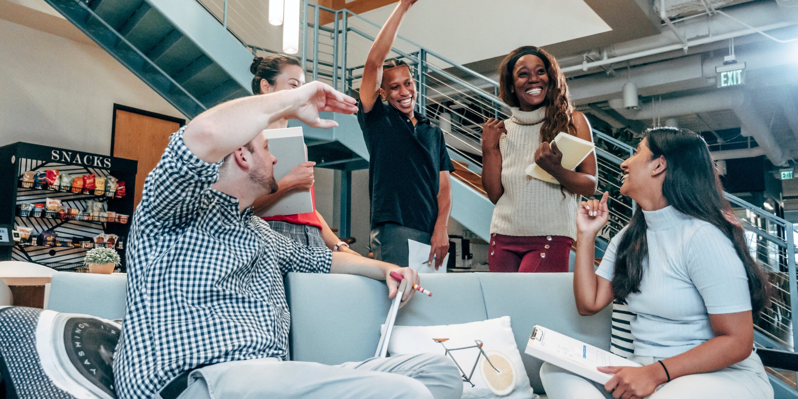 A group of people, some standing and some sitting, celebrate together.