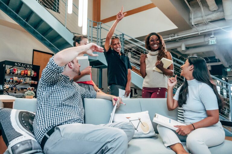 A group of people, some standing and some sitting, celebrate together.