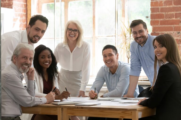 A group of smiling people gathered around a table.