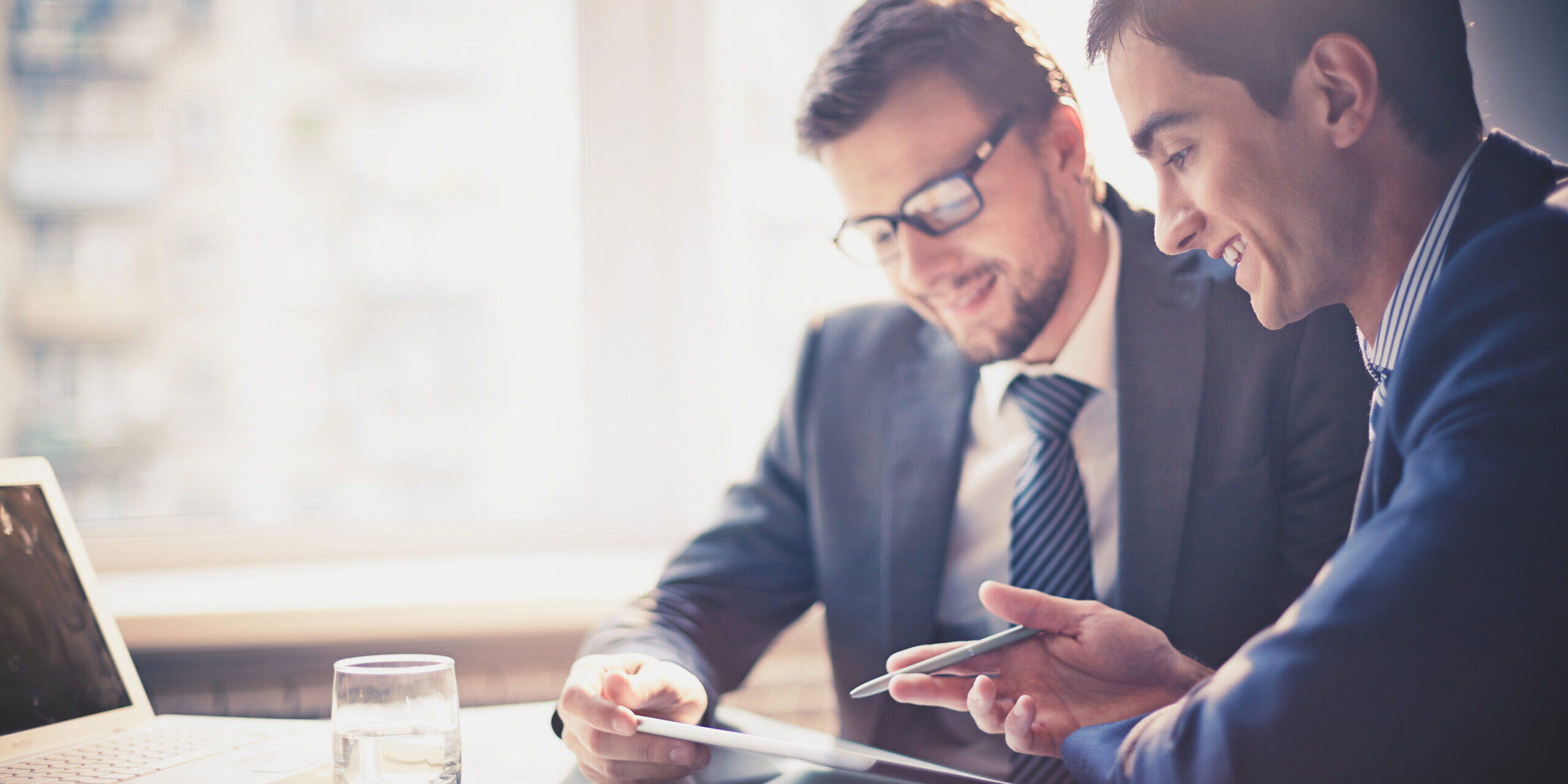 Two people have a discussion and refer to a piece of paper.