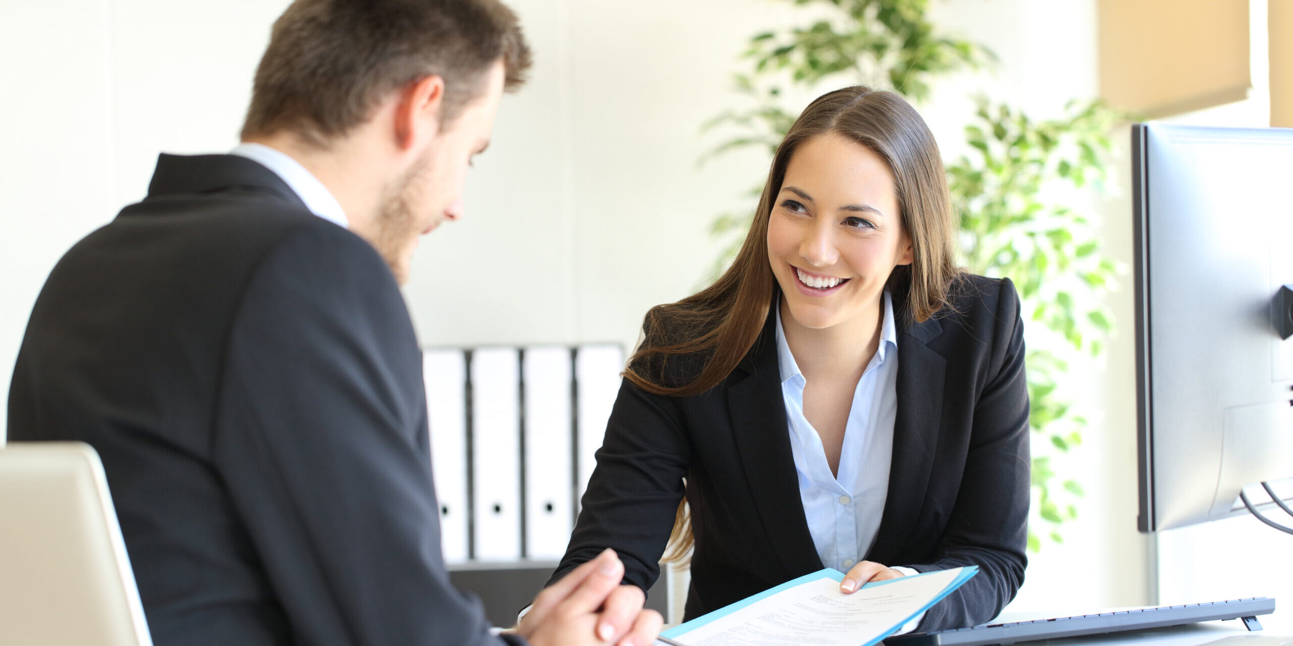 A man and a woman having a discussion in an office.