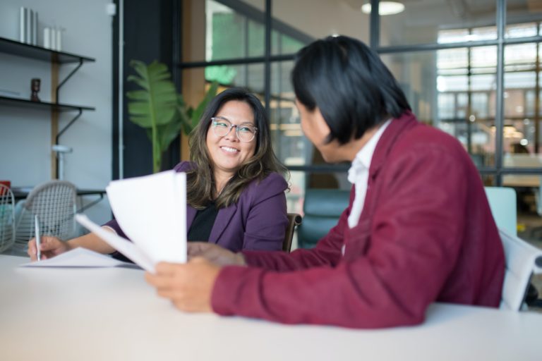 Two people talking in an office.