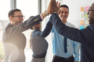 Office workers doing a team high five. 