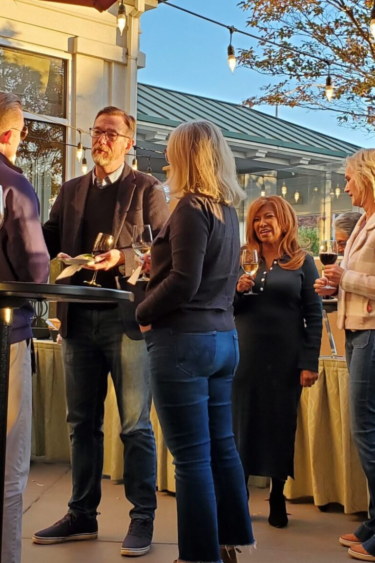 Seminar attendees having conversations over wine at the reception.