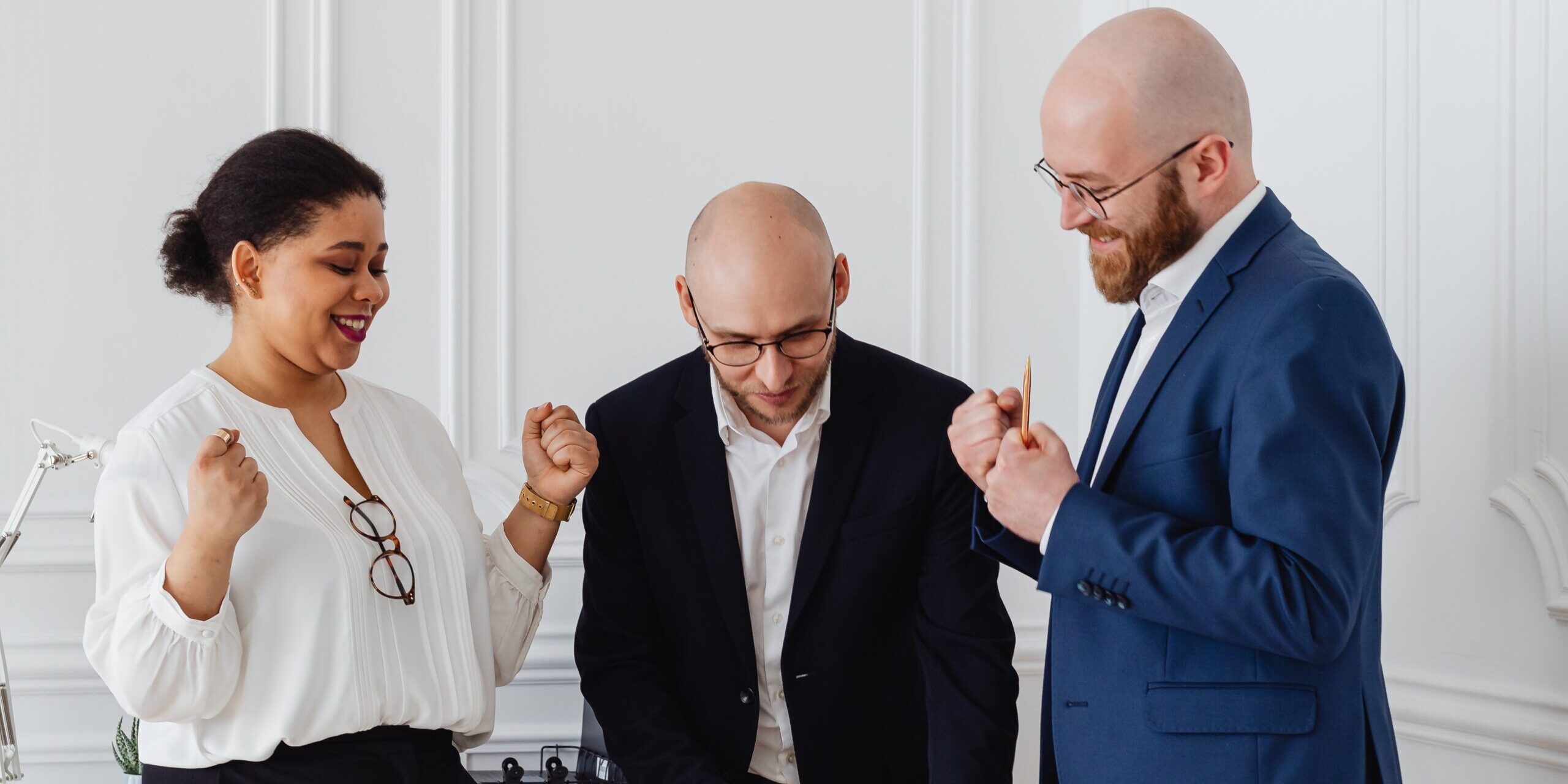 A group of three business people looking happy and successful.