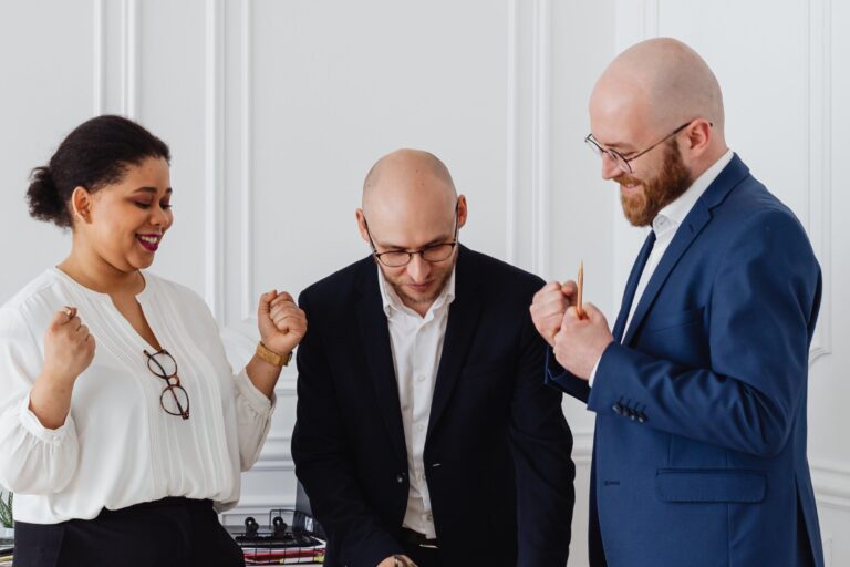 A group of three business people looking happy and successful.