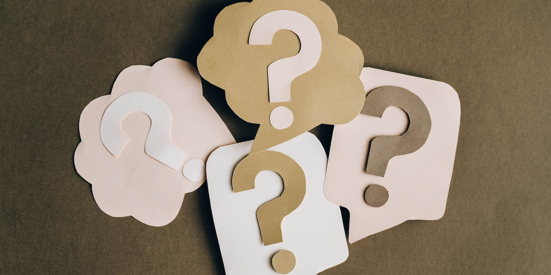 Stylized cutouts of question marks, two in thought bubbles and two in speech bubbles.