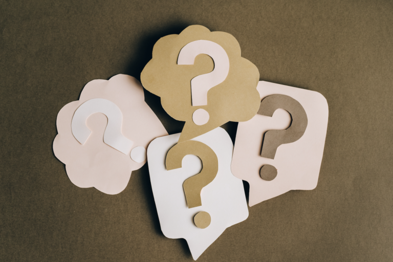 Stylized cutouts of question marks, two in thought bubbles and two in speech bubbles.