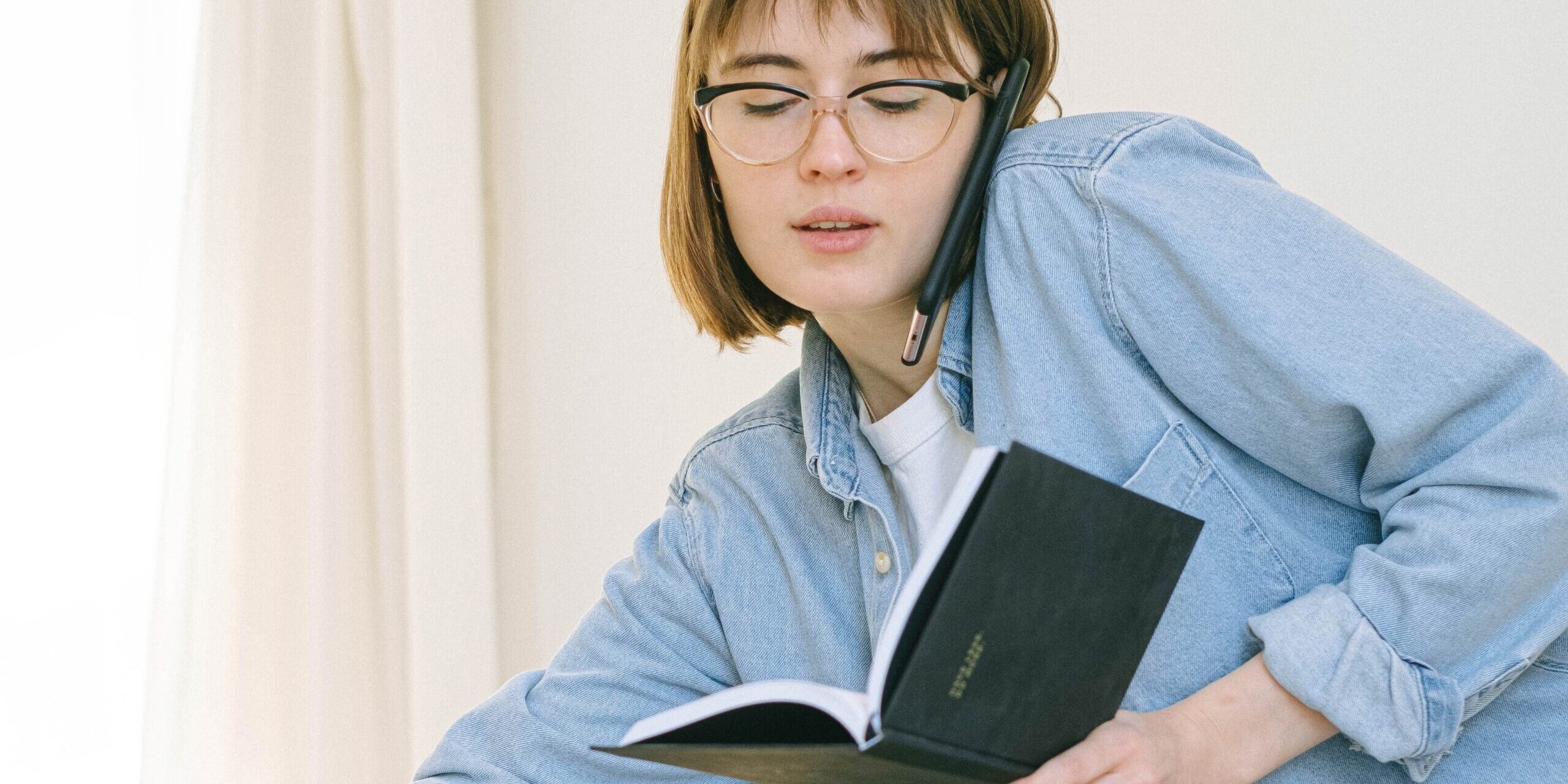 A woman holding and looking down at a book.