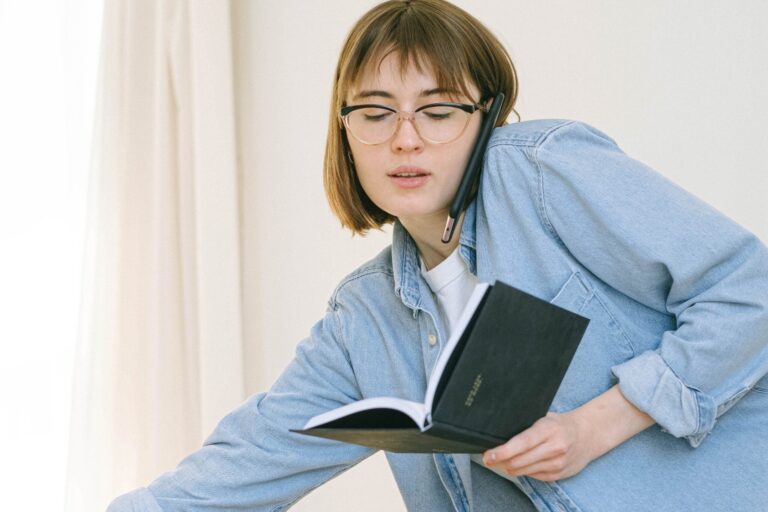 A woman holding and looking down at a book.