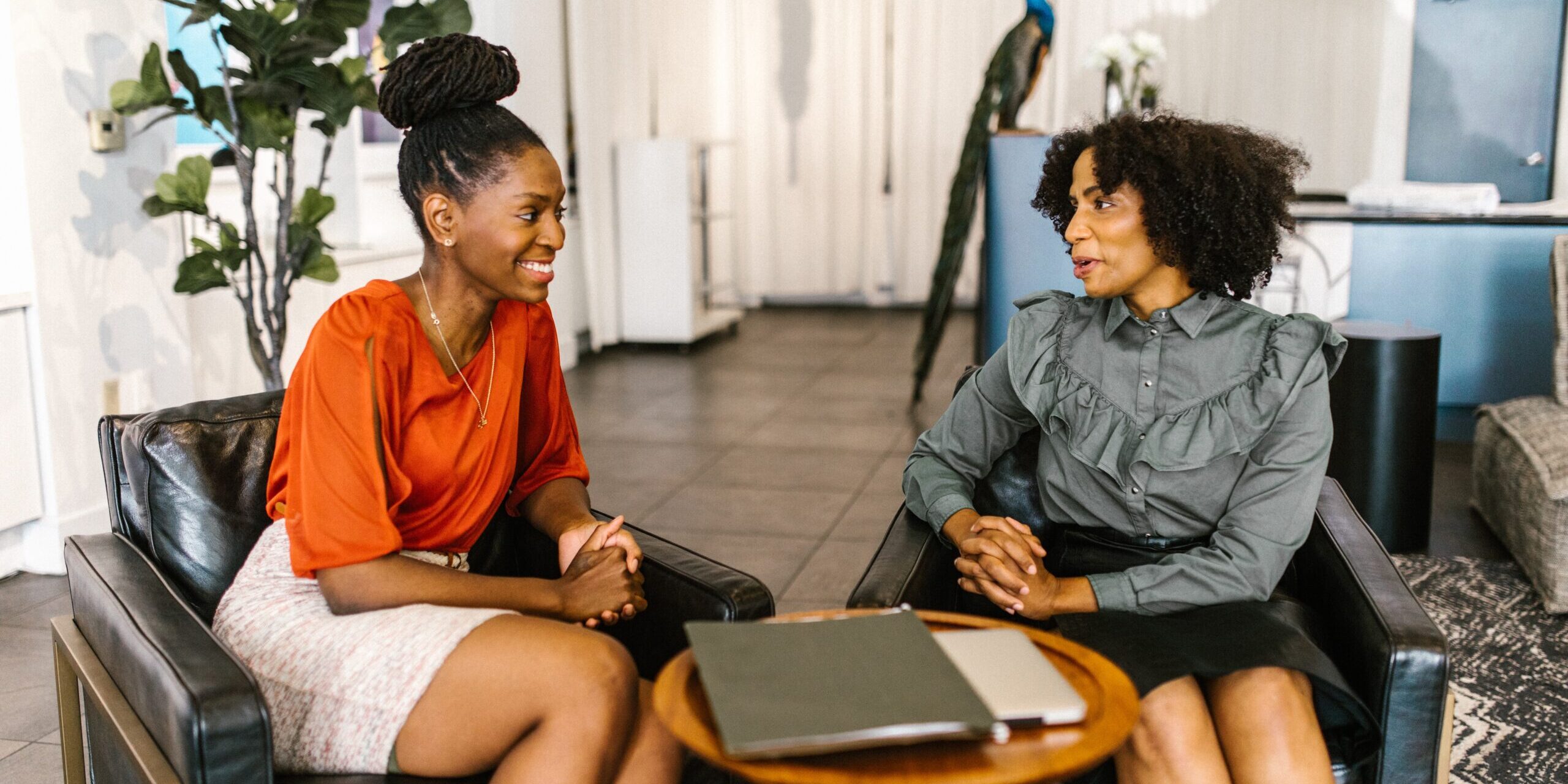 Two women in a professional setting talking to each other.