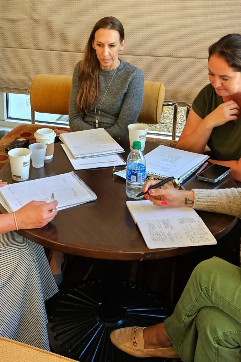 Four seminar attendees having a group discussion around a table.