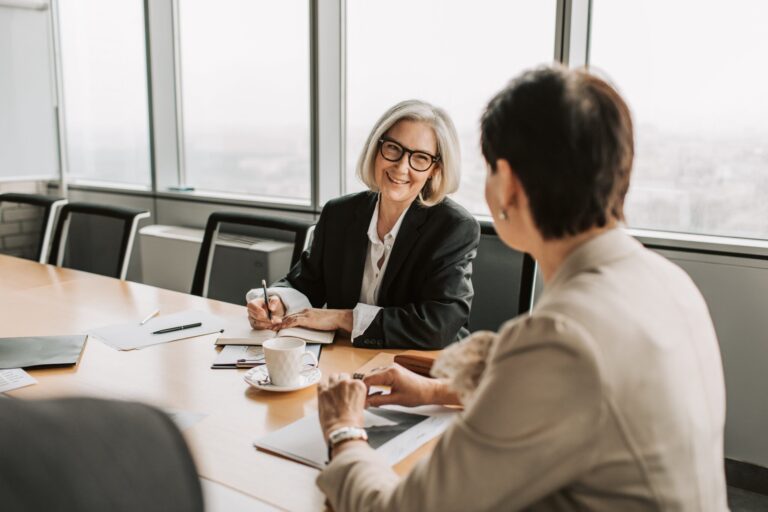 One woman coaching another in an office setting.