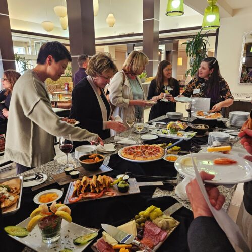 Seminar attendees filling their plates from a table full of food.