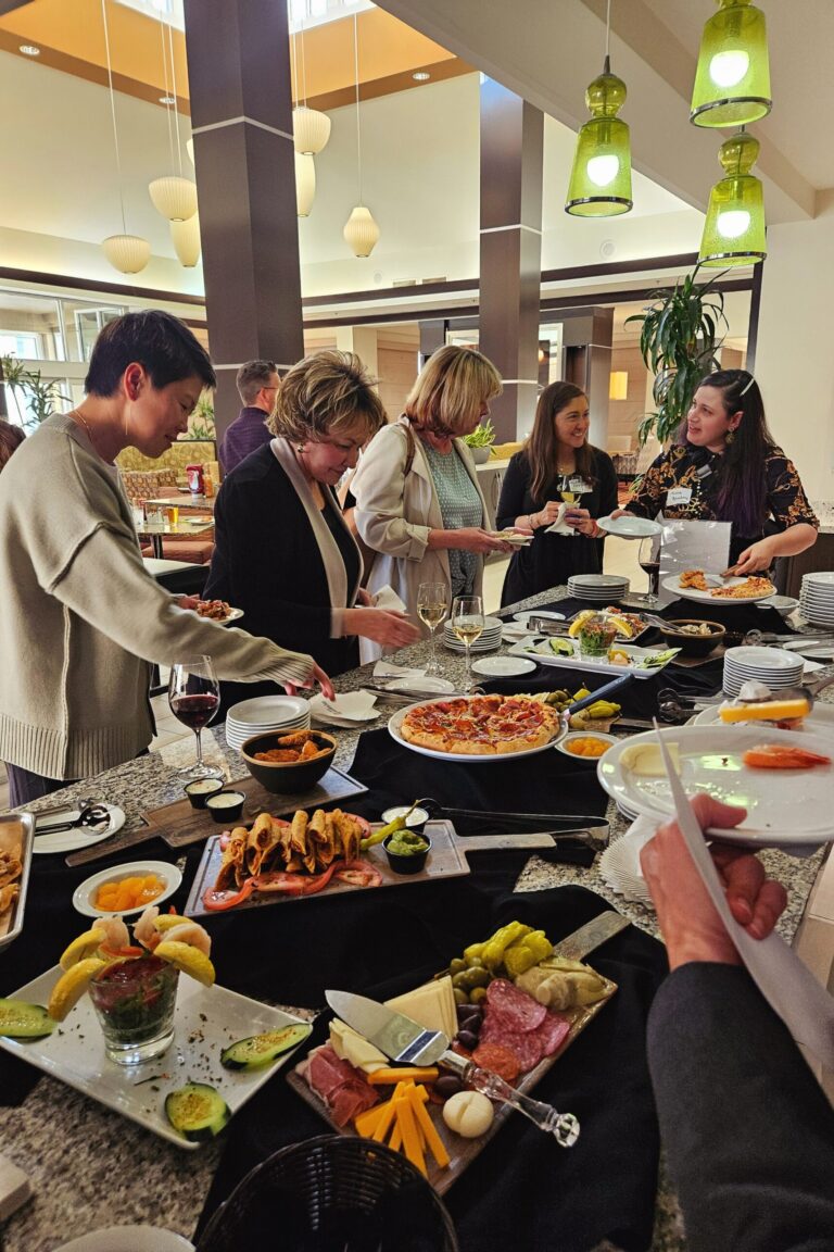 Seminar attendees filling their plates from a table full of food.
