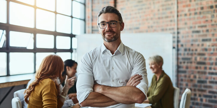 A business man with his arms crossed looking directly at you.