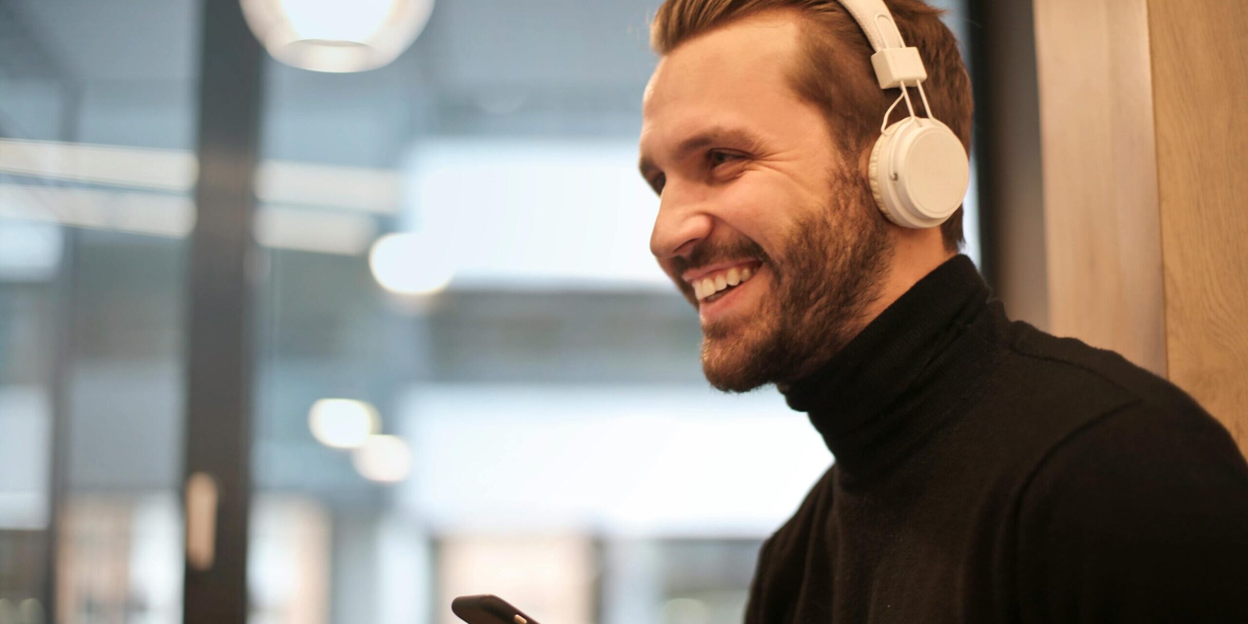 Man wearing white headphones listening to audio coaching.