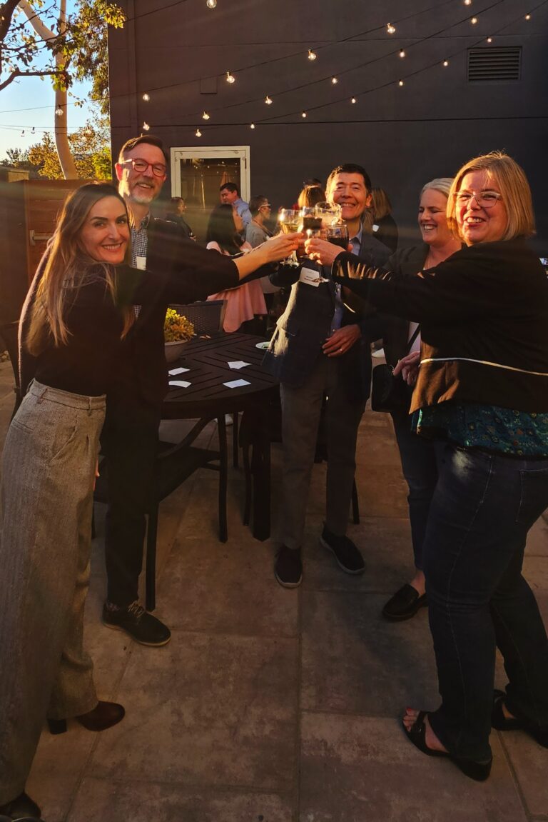 Seminar attendees and instructors toasting and smiling.