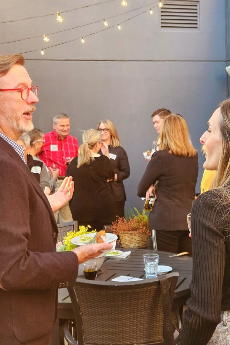 Seminar attendees and instructors chatting and eating during a seminar afterparty.
