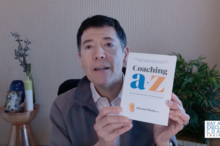 Michael Neuendorff holding up the book Coaching a-z by Haesun Moon