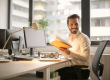 A smiling businessman sitting at his desk.