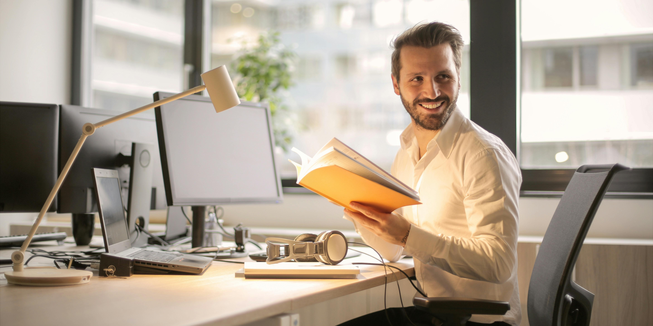 A smiling businessman sitting at his desk.